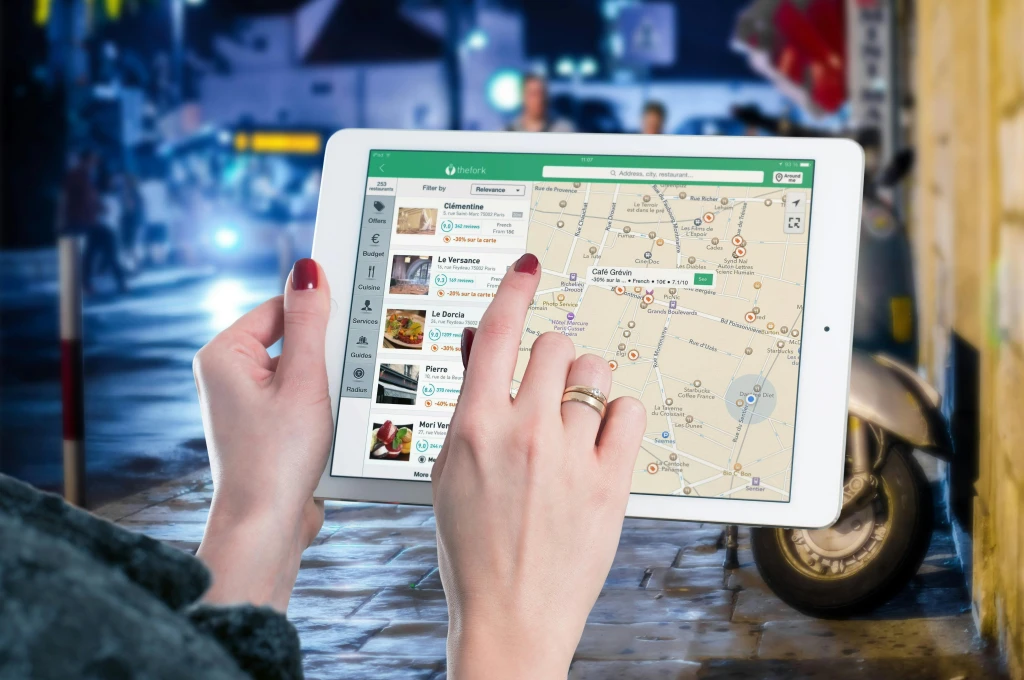 Manos de Mujer con Tablet viendo negocios en Google Maps