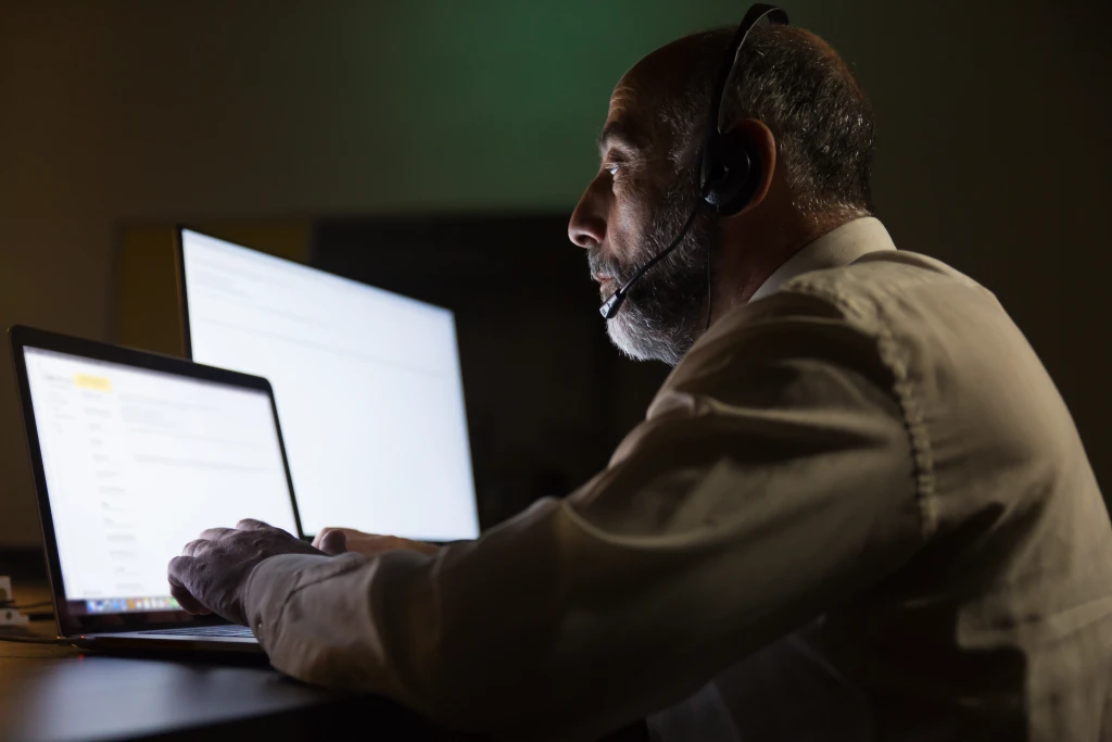 empresario-serio-en-auriculares-usando-laptop.webp